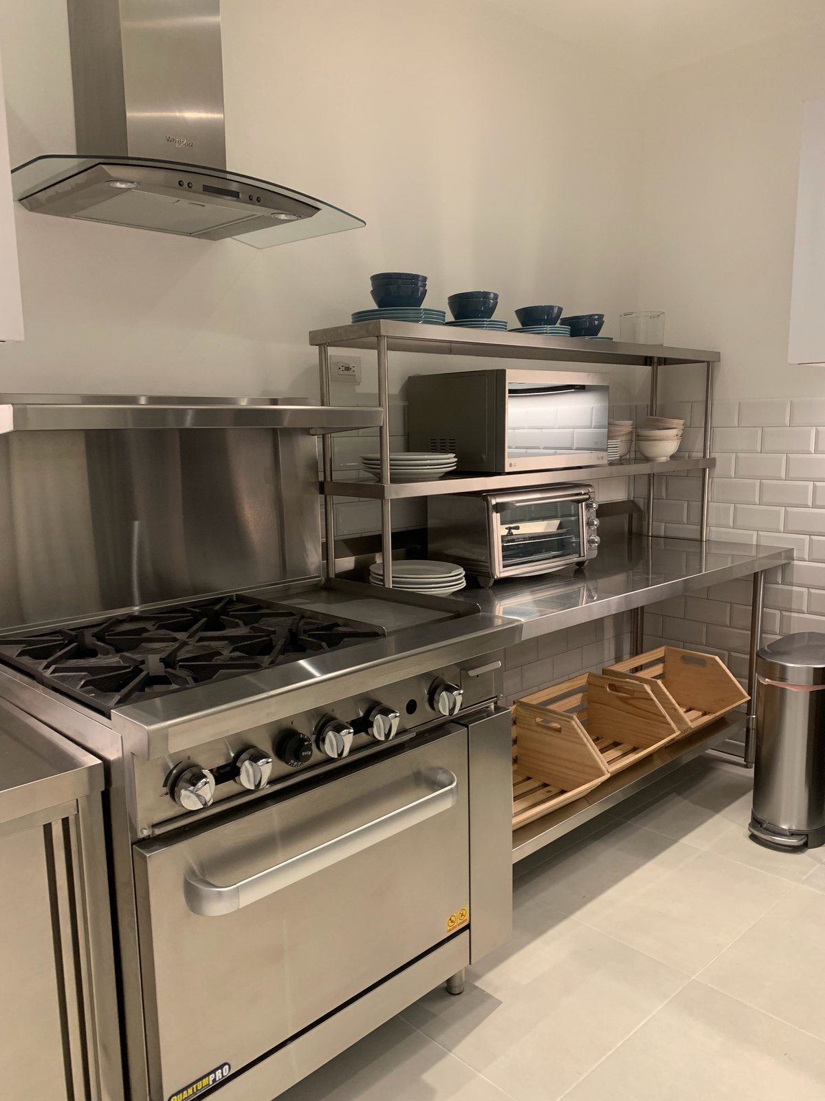 Stainless steel chef’s kitchen with a gas range and shelves stocked for cooking